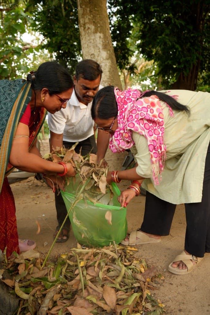 Community members collecting dry leaves during a cleanliness drive